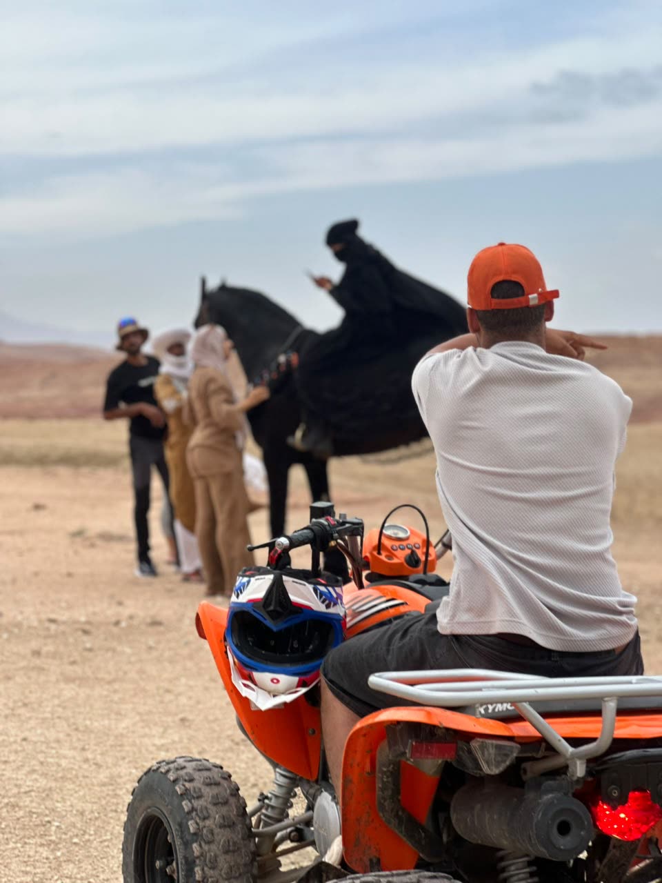 Horse rider and orange quad in the desert